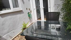 A glass-top table with two chairs, a small potted plant, and a white bowl. - Gorgeous One Bedroom Flat in Woolwich Arsenal (London)