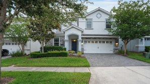 A two-story house with a garage, a front entrance, and a driveway. - 8BR family retreat w/ game room & pool (Four Corners)