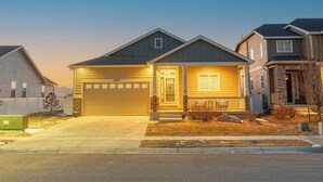 Een woonhuis met garage, voortuin en een verzorgd gazon.