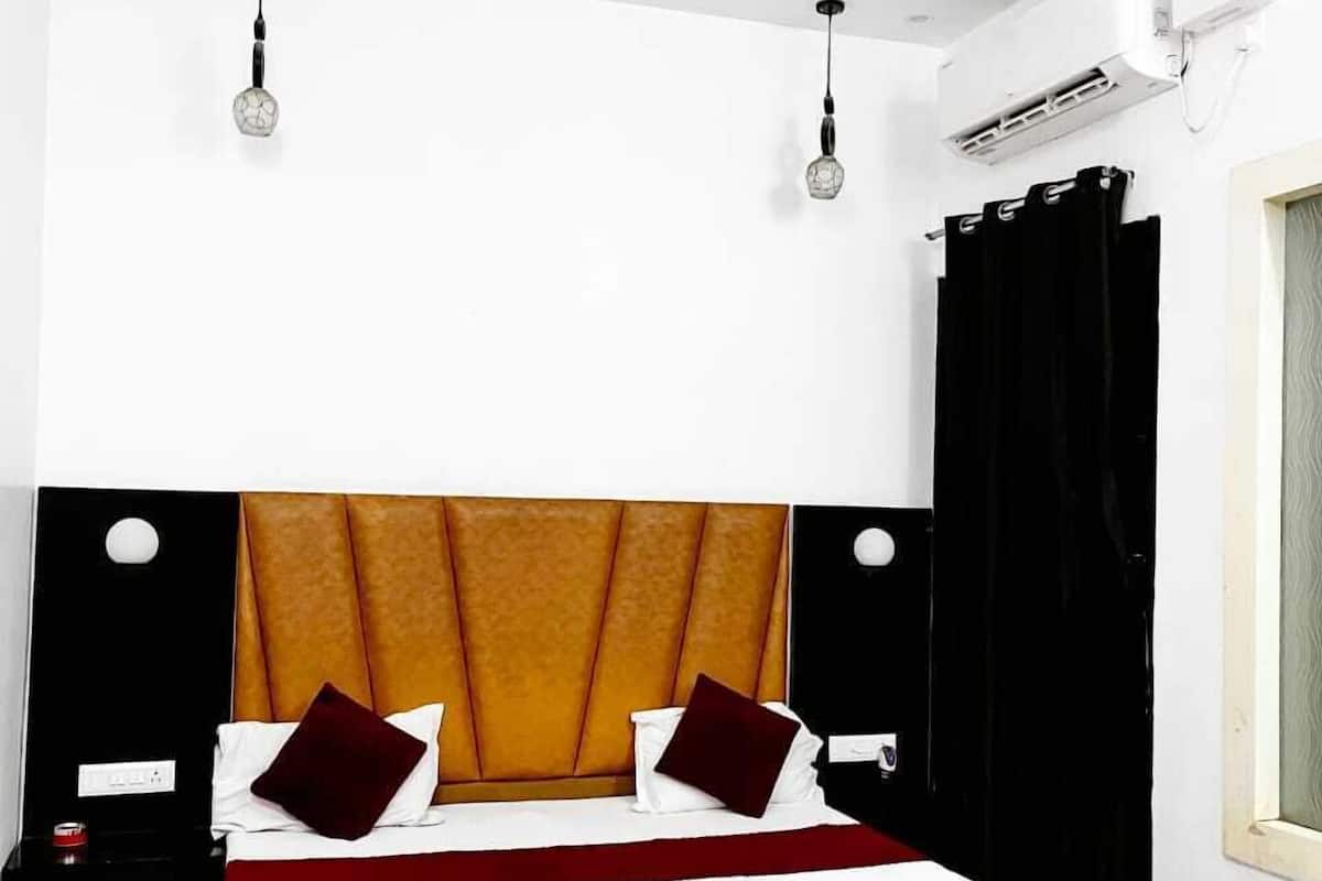 Ein Schlafzimmer mit Bett, Deckenventilator, Klimaanlage und einem Vorhangfenster.
