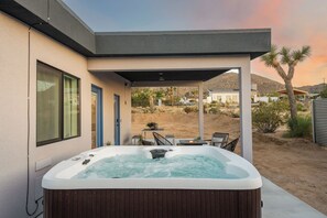 Ein moderner Whirlpool-Bereich mit Terrasse, Sitzgelegenheiten und Blick auf die umliegende Landschaft.