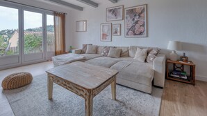 Una sala de estar con sofá, mesa de centro, lámpara y cuadros en la pared.