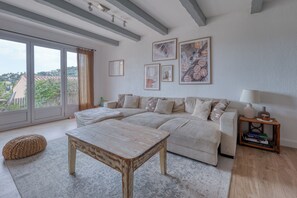 Un salon avec un canapé, une table basse, une lampe et des œuvres d’art encadrées accrochées au mur.