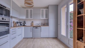 Una cocina moderna con armarios blancos, lavavajillas y encimera de madera.