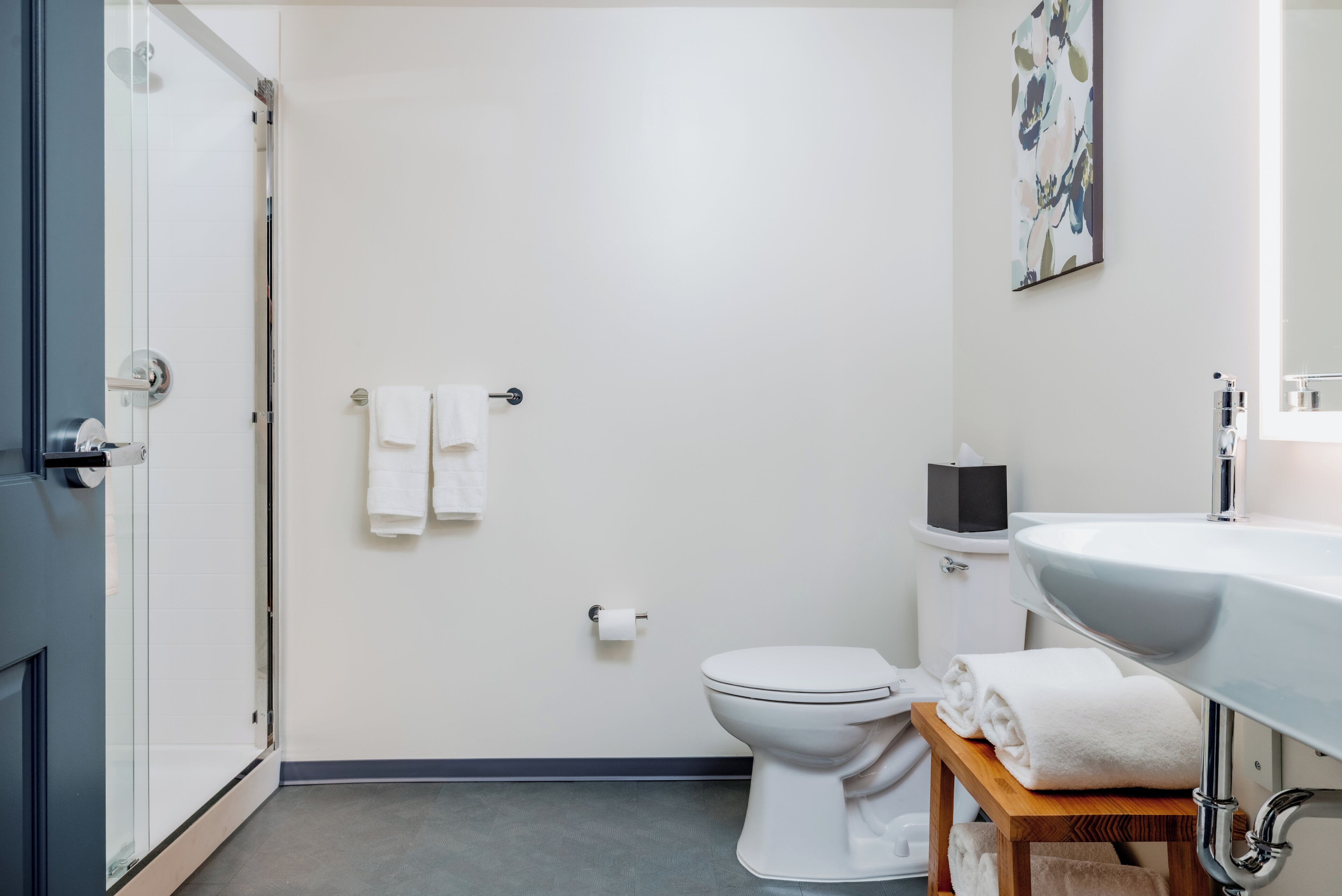 Un baño moderno con inodoro, lavamanos y ducha.