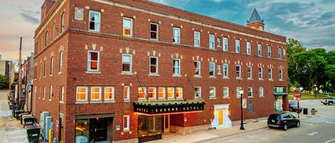 A historic brick building with a theater marquee, a corner entrance, and a visible fire escape.