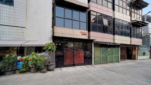 A building with a tiled facade, a large window, and a sign that reads 'PANDA AIR.' - Hotel O near RS Husada formerly Pondokan (Jakarta)