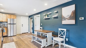 Una cocina moderna con un refrigerador de acero inoxidable, armarios de madera y una pared de acento azul.