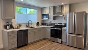 A modern kitchen with stainless steel appliances, a dishwasher, and a microwave.