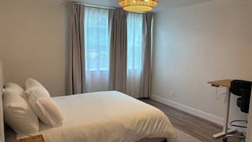 2 habitaciones, escritorio y tabla de planchar con plancha