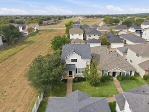 A residential area with houses, a clear sky, and a road in the distance. - Katy Family Home with Patio Pergola and Grill (Katy)