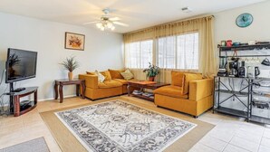 Un salon comprenant un canapé, un téléviseur, une table basse et un tapis décoratif.