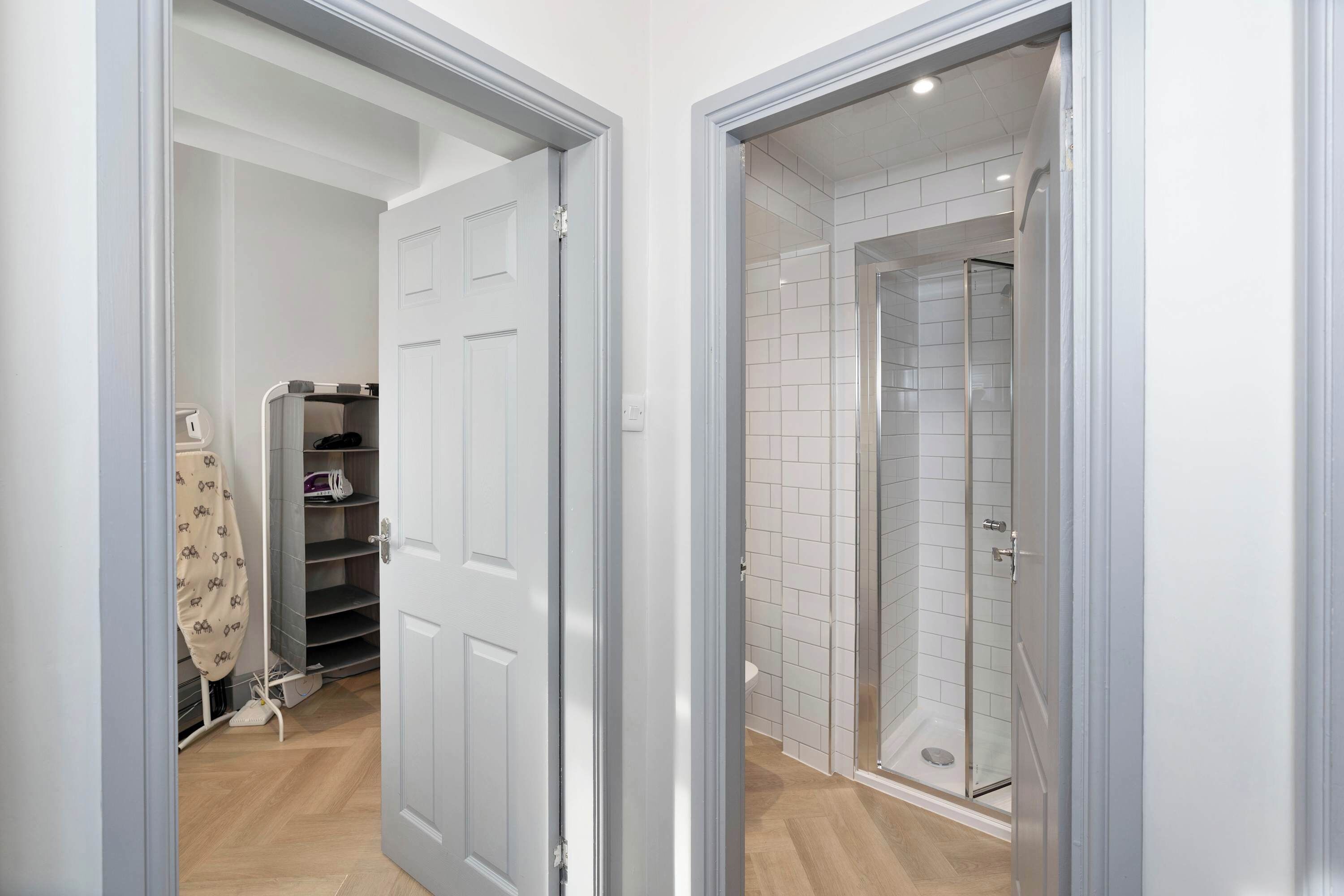 A modern bathroom with a glass shower enclosure and a white tiled shower area.