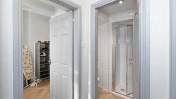 A modern bathroom with a glass shower enclosure and a white tiled shower area.
