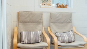 Two wooden chairs with cushions and a small round basket with a blanket on the floor. - Maple Haven, Algonquin Woods (Perry)
