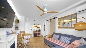 A modern living room with a sofa, dining area, and kitchen. - Marbella Sky Retreat el Nido Suite (Marbella)