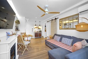 A modern living room with a sofa, dining area, and kitchen. - Marbella Sky Retreat el Nido Suite (Marbella)