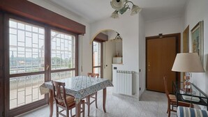 Un coin repas comprenant une table et des chaises, un radiateur, une porte et une fenêtre donnant sur un paysage agréable.