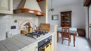 Une cuisine équipée d’une cuisinière à gaz, d’un four et d’un coin repas avec une table et des chaises.