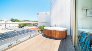 A rooftop with a wooden deck, a hot tub, and solar panels. - 2 Br condo with Rooftop Pool - Doca 303 (Playa del Carmen)