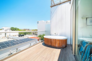 A rooftop with a wooden deck, a hot tub, and solar panels. - 2 Br condo with Rooftop Pool - Doca 303 (Playa del Carmen)