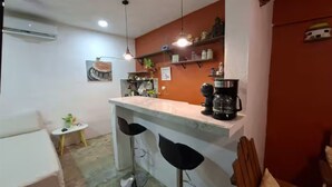 A compact kitchen with a bar area, a small dining table, and a single chair. - Dager Cottage (Mérida,)