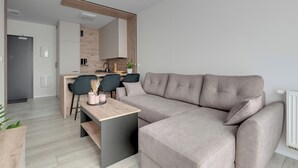 Una sala de estar moderna con un sofá, una mesa de comedor y una zona de cocina.