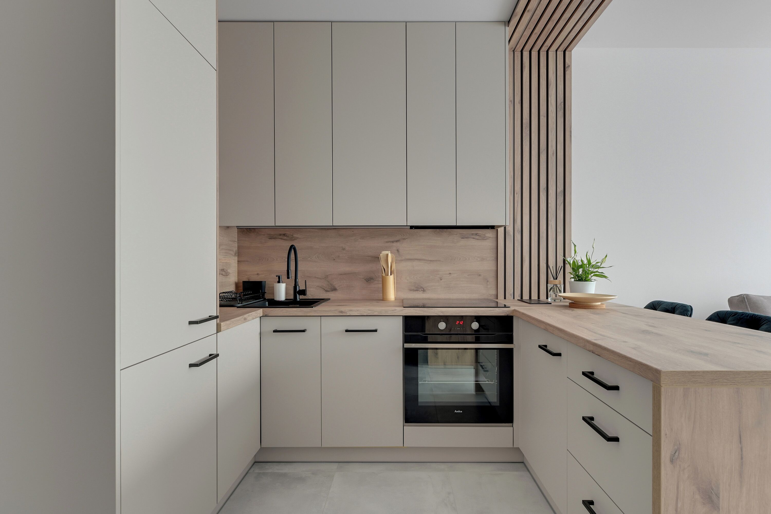 Una cocina moderna con horno empotrado, encimera de madera y diseño minimalista.