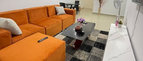 A living room with a sofa, coffee table, and a painting on the wall.