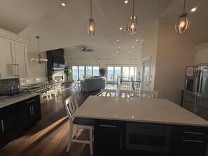 A spacious kitchen with a large island, modern appliances, and a view to the outside. - Beautiful bayfront 5-bedroom, 4.5-bathroom home with in-ground pool! (Lower Township)