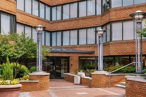 A modern building with a brick facade, large windows, and outdoor seating areas. - Global Luxury Suites at Georgetown (Washington)