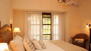 A bedroom with a bed, curtains, a window, a chair, and a lamp. - La Matera Posada de Campo (San Rafael)