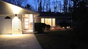 A residential house with a garage, a front door, and a well-lit entrance.