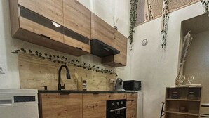 A kitchen with wooden cabinets, a built-in oven, a microwave, and a sink. - Deadwood (Berlaimont)