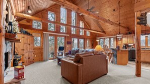 A log cabin interior with a living room, kitchen, and large windows. - Rustic Ridge Cabin 102 - Private Woodland Retreat near Devil's Lake State Park (Merrimac)
