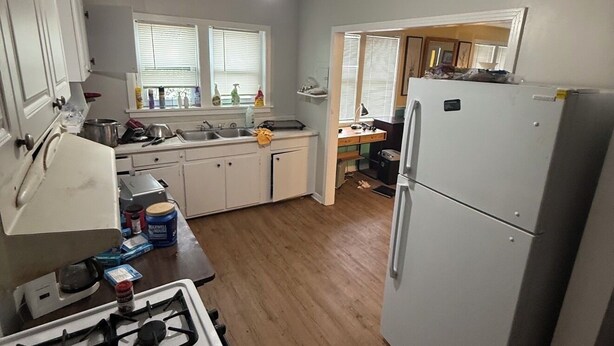 A kitchen with a gas stove, white cabinets, a refrigerator, and a ceiling fan. - Studio efficiency in the heart of downtown Saint Augustine (St. Augustine)