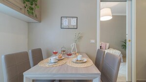 Un tavolo da pranzo con sottopiatti, un vaso con fiori e una citazione incorniciata al muro.