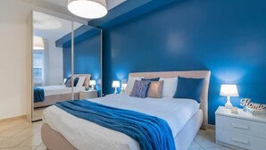 Una camera da letto con un letto, comodini, uno specchio e un tavolino di servizio.