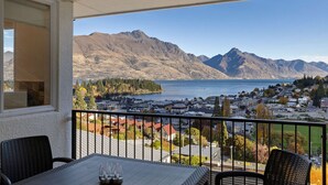 A balcony with a table and chairs, overlooking a lake and mountains. - Spectacular Views, Walk To Town, Freshly Renovated (Queenstown)