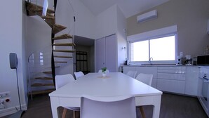 Et moderne køkken med hvide skabe, indbygget ovn og et vindue.