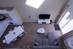 Ein zeitgemäßer Wohnbereich mit Essplatz, Sofa und Fernseher.