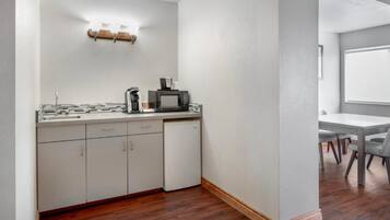 A compact kitchen with a microwave, coffee maker, and a small refrigerator.