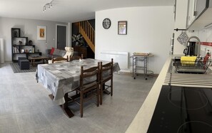 A dining area with a table, chairs, a kitchen counter, and a staircase. - Gîte des Voines - MAILLE (MAILLE)