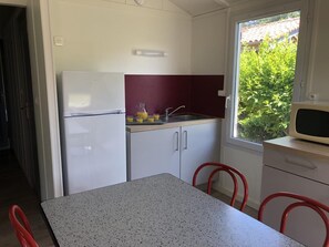 A compact kitchen with a refrigerator, sink, and window. - Chalet N° 4 - SAINT SECONDIN (SAINT SECONDIN)