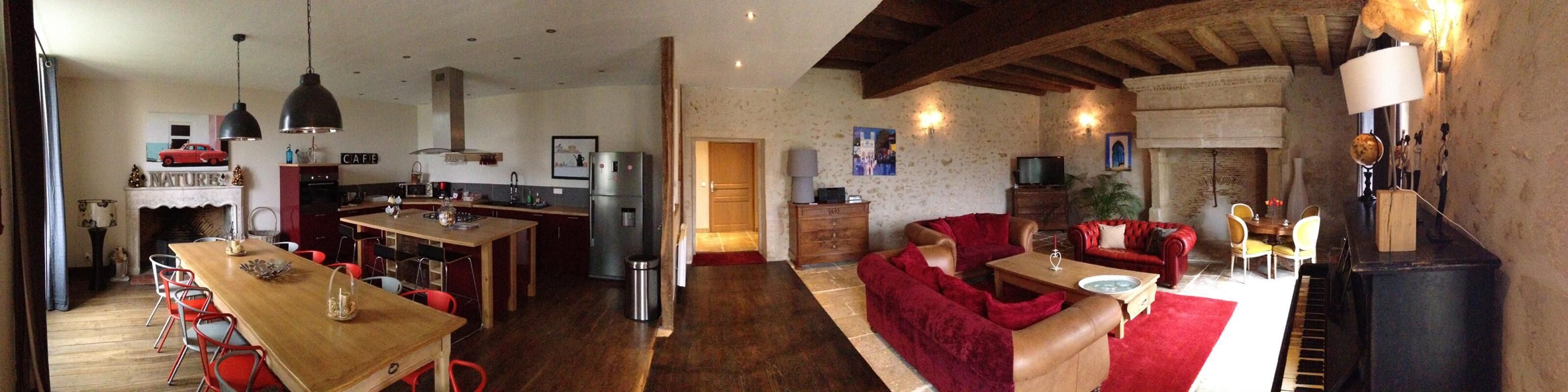 Uma sala de estar aconchegante com lareira, área de jantar e cozinha.
