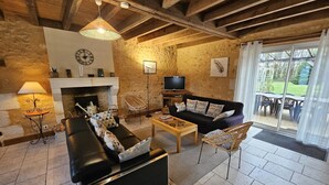 A living room with a fireplace, a sofa, a coffee table, and a television. - The Gallinaceans - LUSIGNAN (LUSIGNAN)