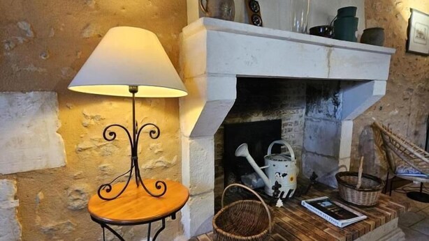 A fireplace with a clock above it, a table with a lamp beside it, and a basket on the mantel. - The Gallinaceans - LUSIGNAN (LUSIGNAN)