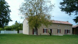 A two-story house with a red-tiled roof, a small garden, and a tree in front. - Les Cèdres - BLANZAY - Gîte (BLANZAY)