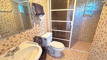 A bathroom with a toilet, sink, and a mirror.