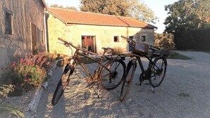 Dos bicicletas estacionadas frente a un edificio con camino de grava.